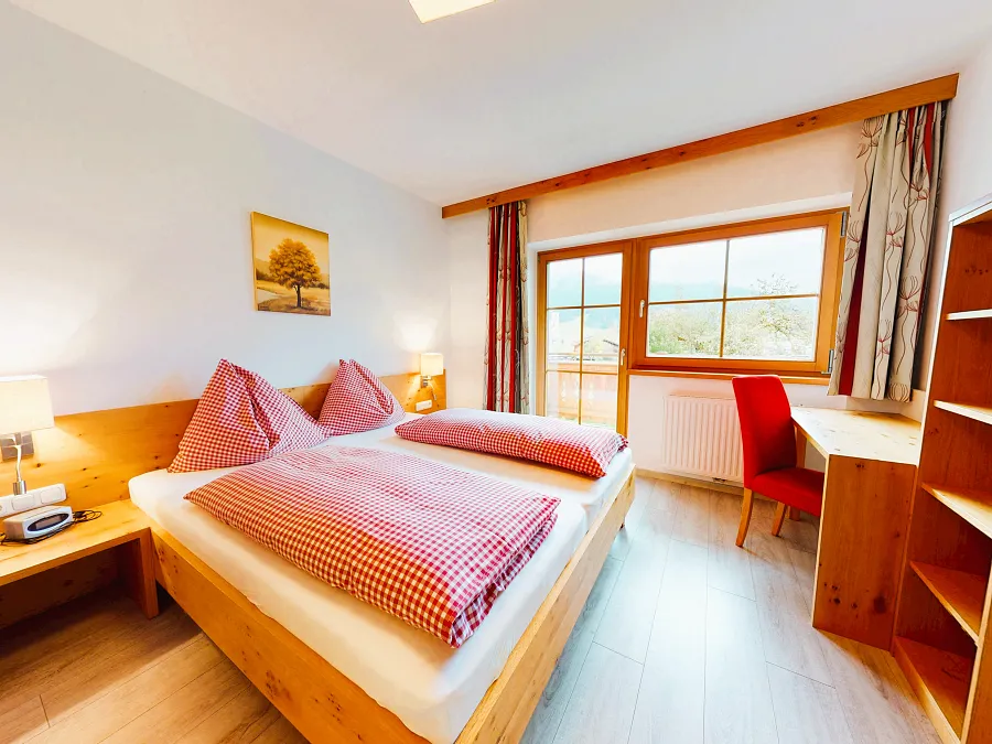 Schlafzimmer mit Doppelbett und Balkontür im Appartement Hartkaiser